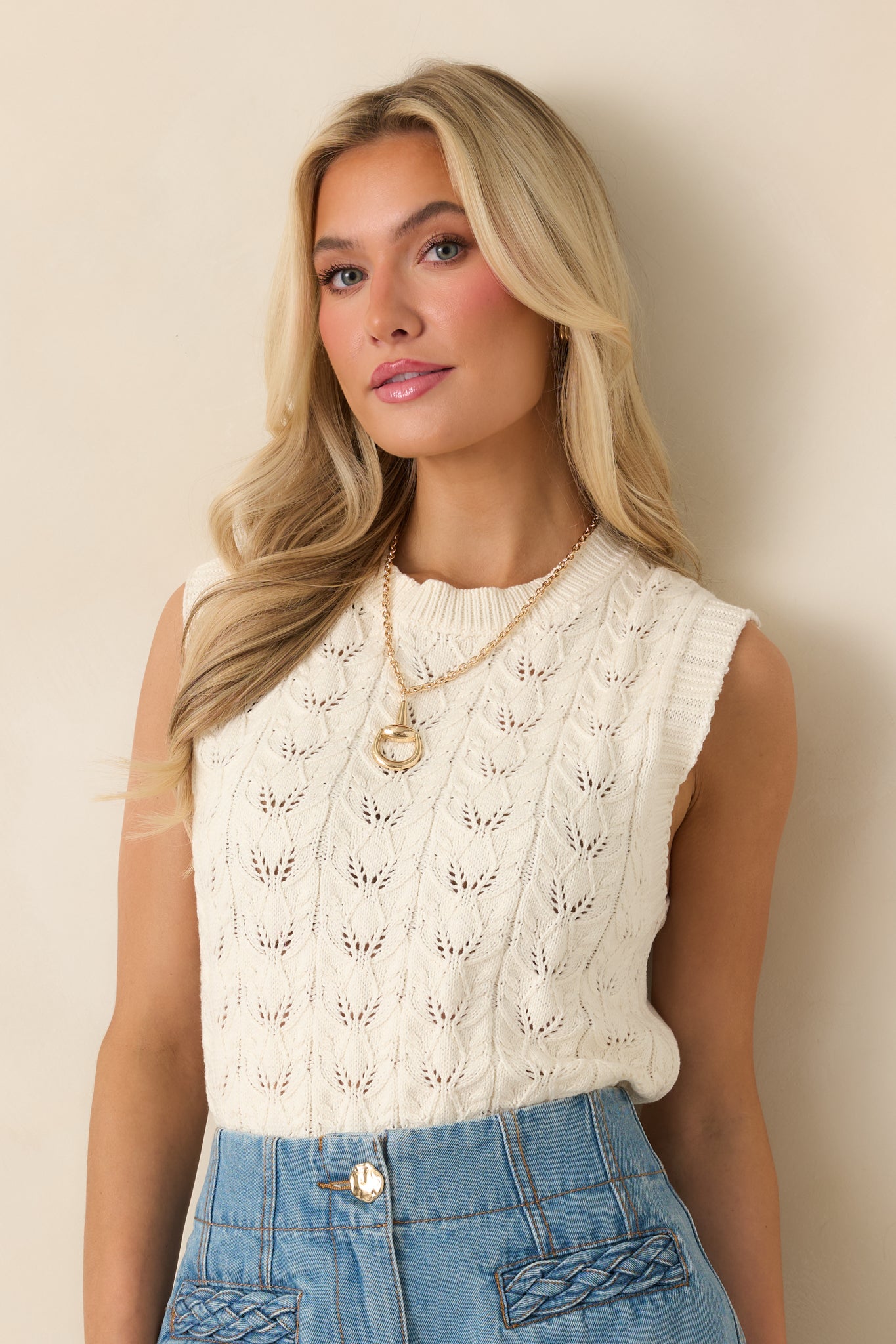 Cropped view focusing on crew neckline and textured knit pattern across chest.