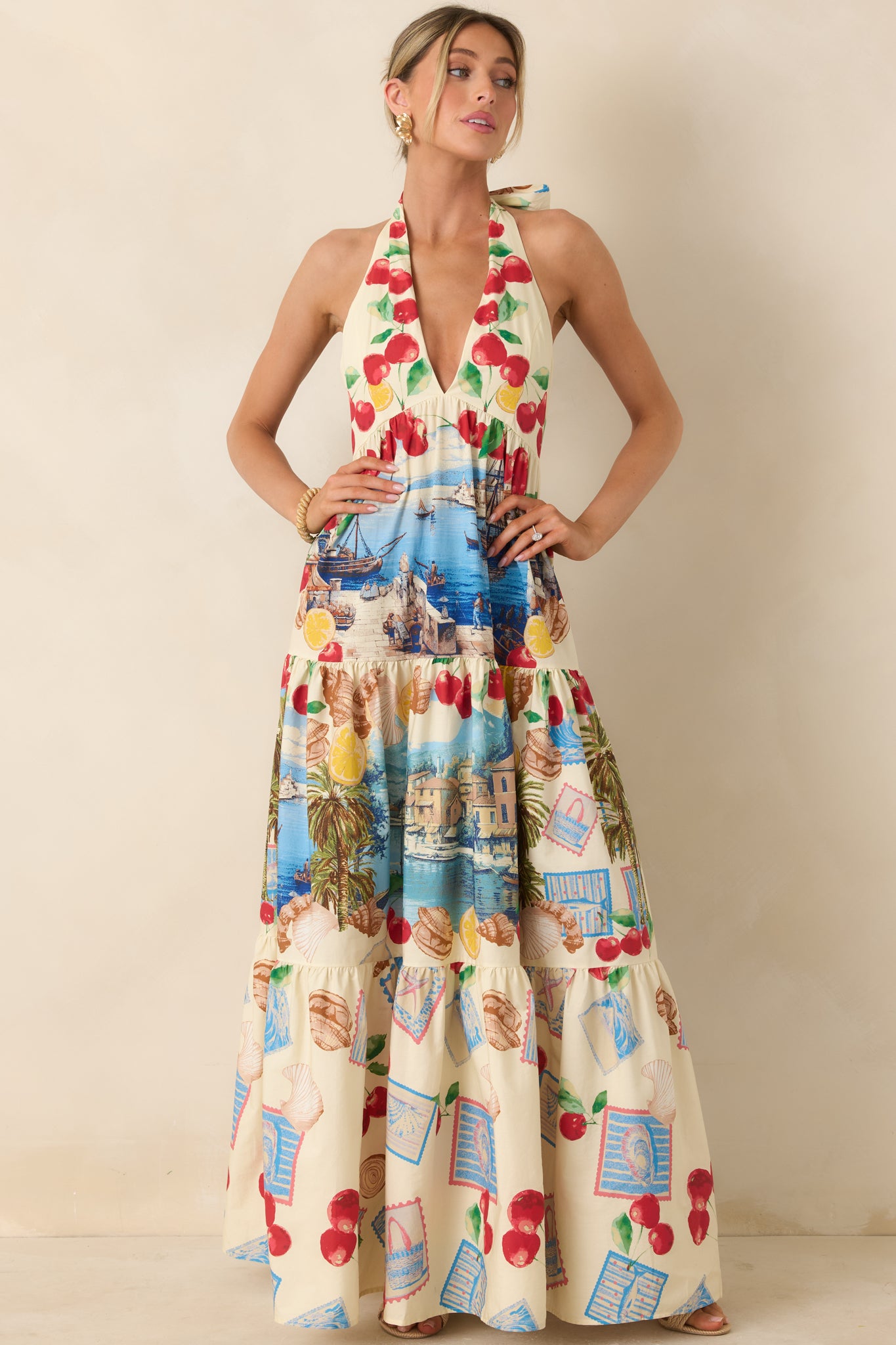 Tiered maxi dress featuring a vivid Mediterranean-inspired print, halter neckline, and flowing silhouette with effortless movement.