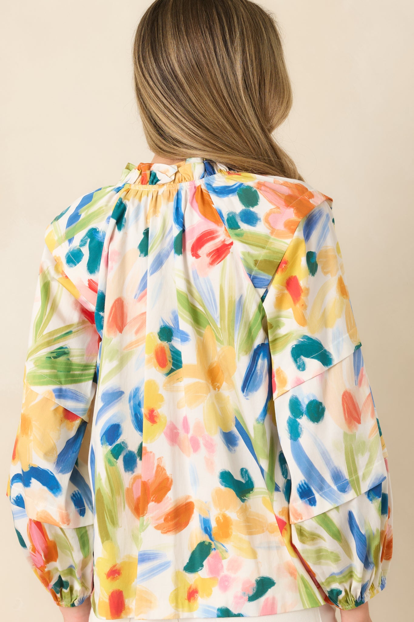 Rear view of the multicolored floral top showing the relaxed fit, straight hemline, and lightweight woven texture.