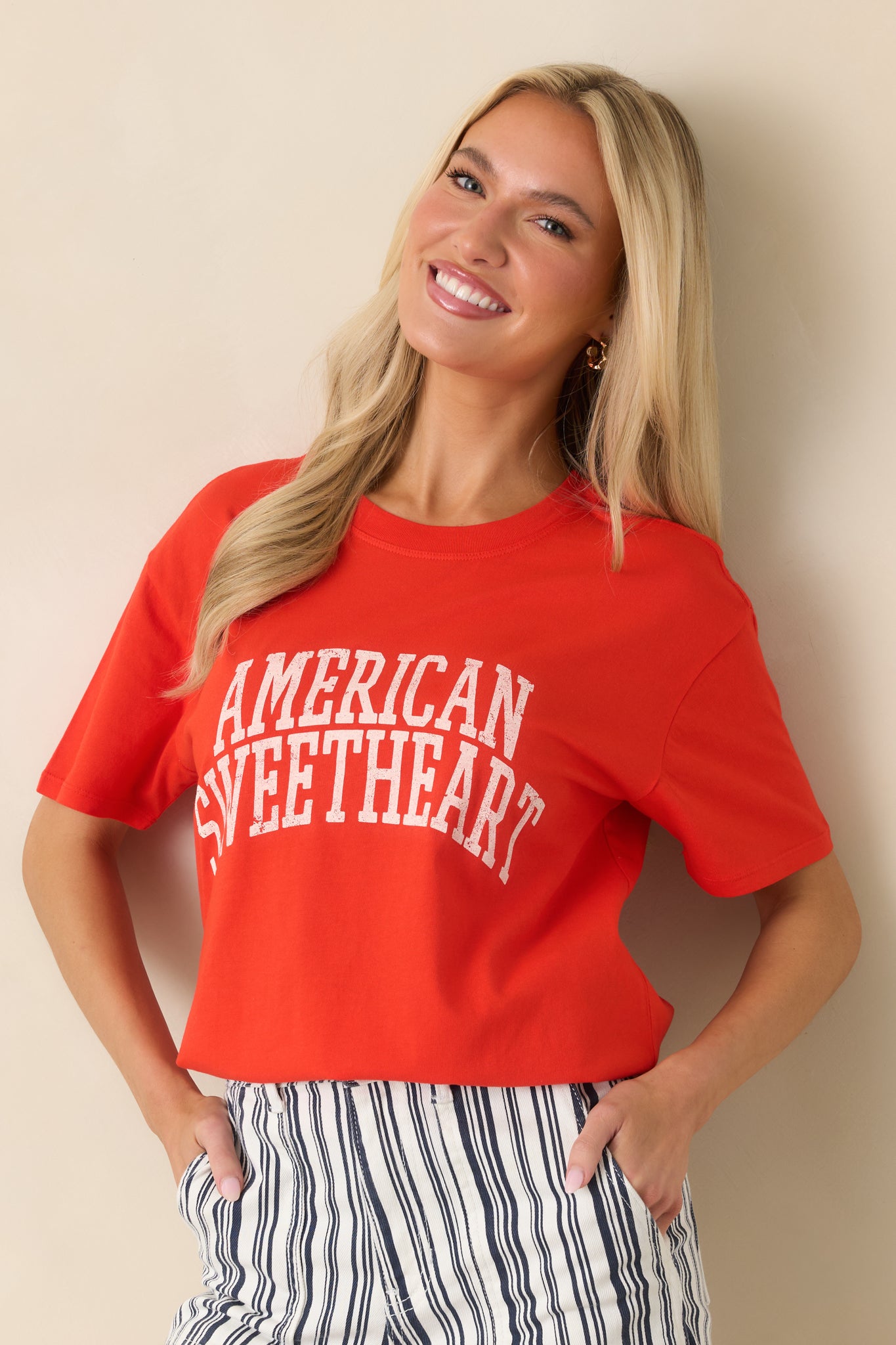 Relaxed boyfriend-style t-shirt with short sleeves and faded graphic detail on bright red fabric.