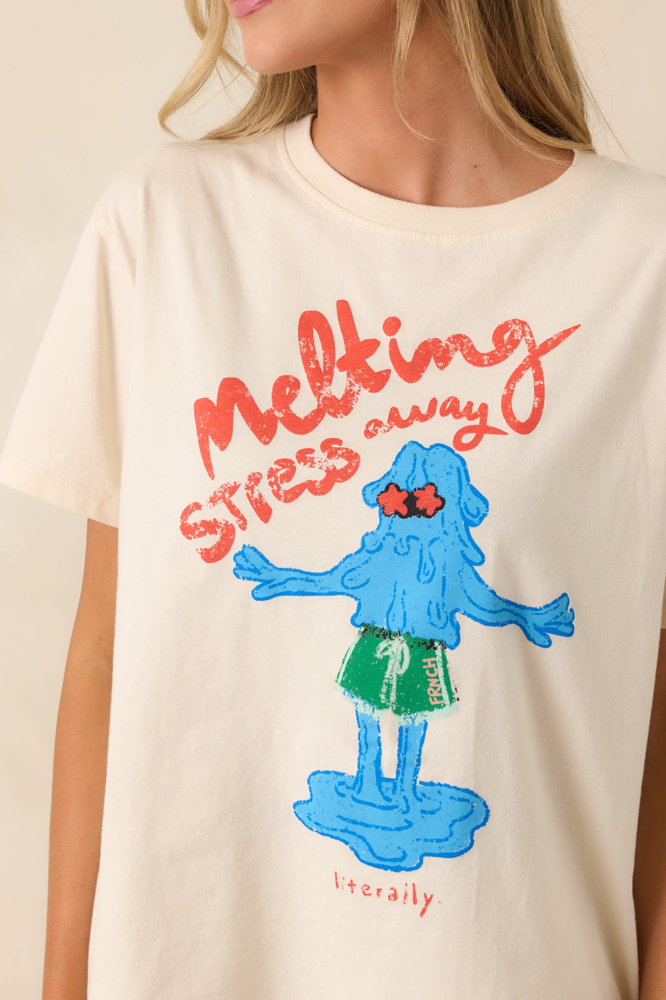 Close-up of “melting stress away… literally” graphic with colorful dripping text on soft ivory cotton fabric.