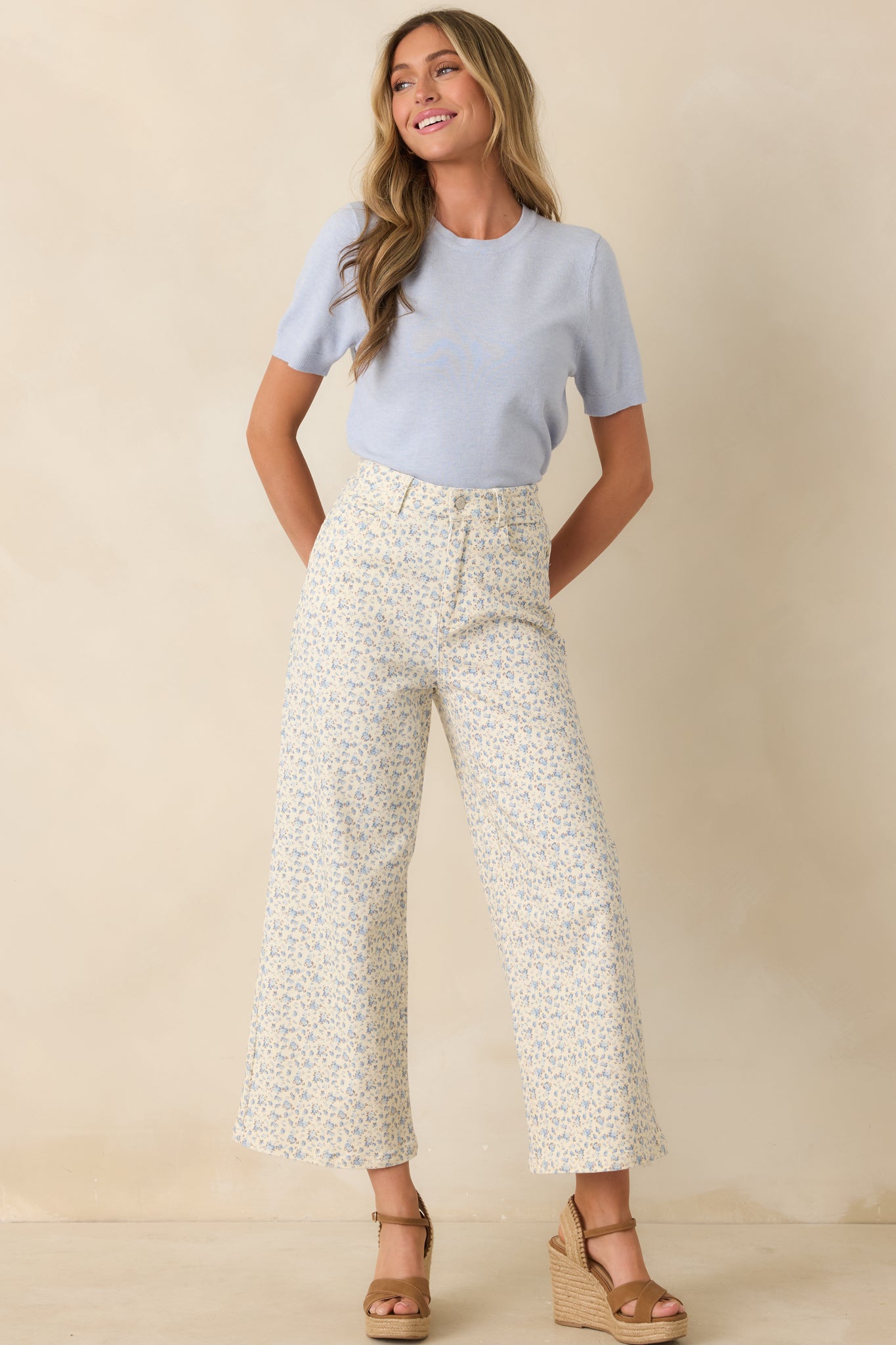 Floral denim jeans showcasing a relaxed wide-leg shape with a zipper and button front closure and soft blue patterning throughout.