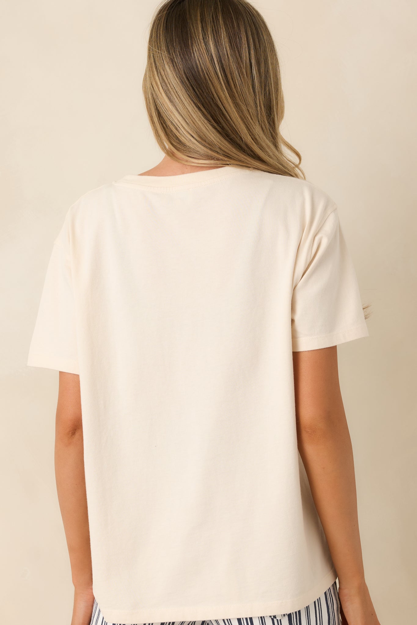 Rear view of ivory t-shirt showing relaxed fit, clean design, and classic short sleeve silhouette.

