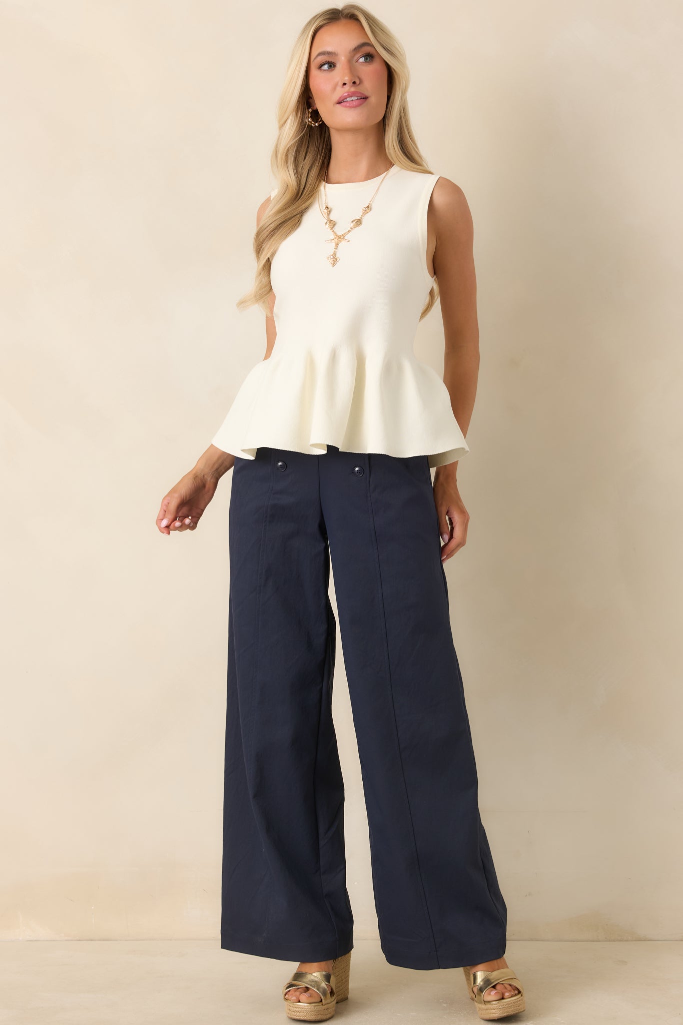 Tailored knit top with feminine peplum hem and clean, minimal design.