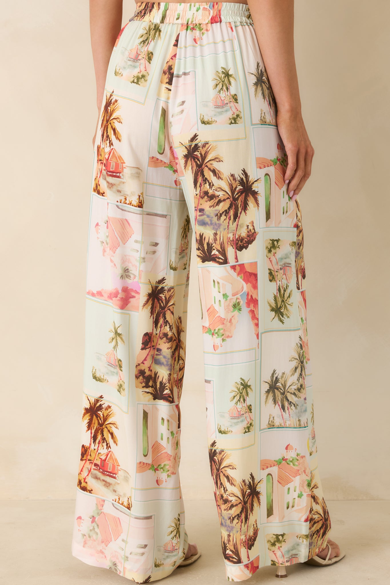 Back view of wide-leg drawstring pants in a vintage postcard print, featuring a relaxed fit and flowing silhouette