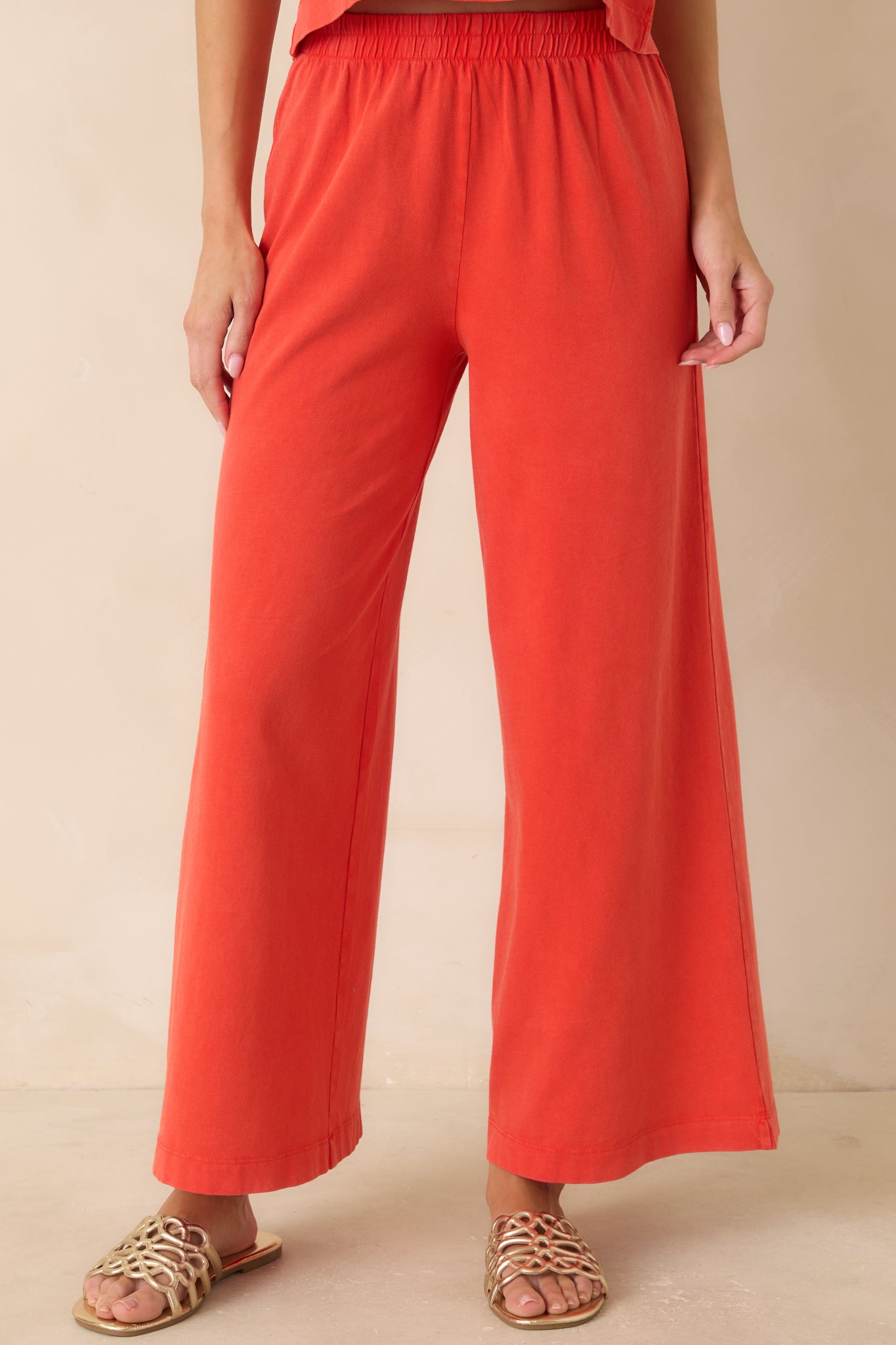 Cropped detail of the poppy red lounge pants showcasing the breathable jersey fabric and relaxed pull-on fit.