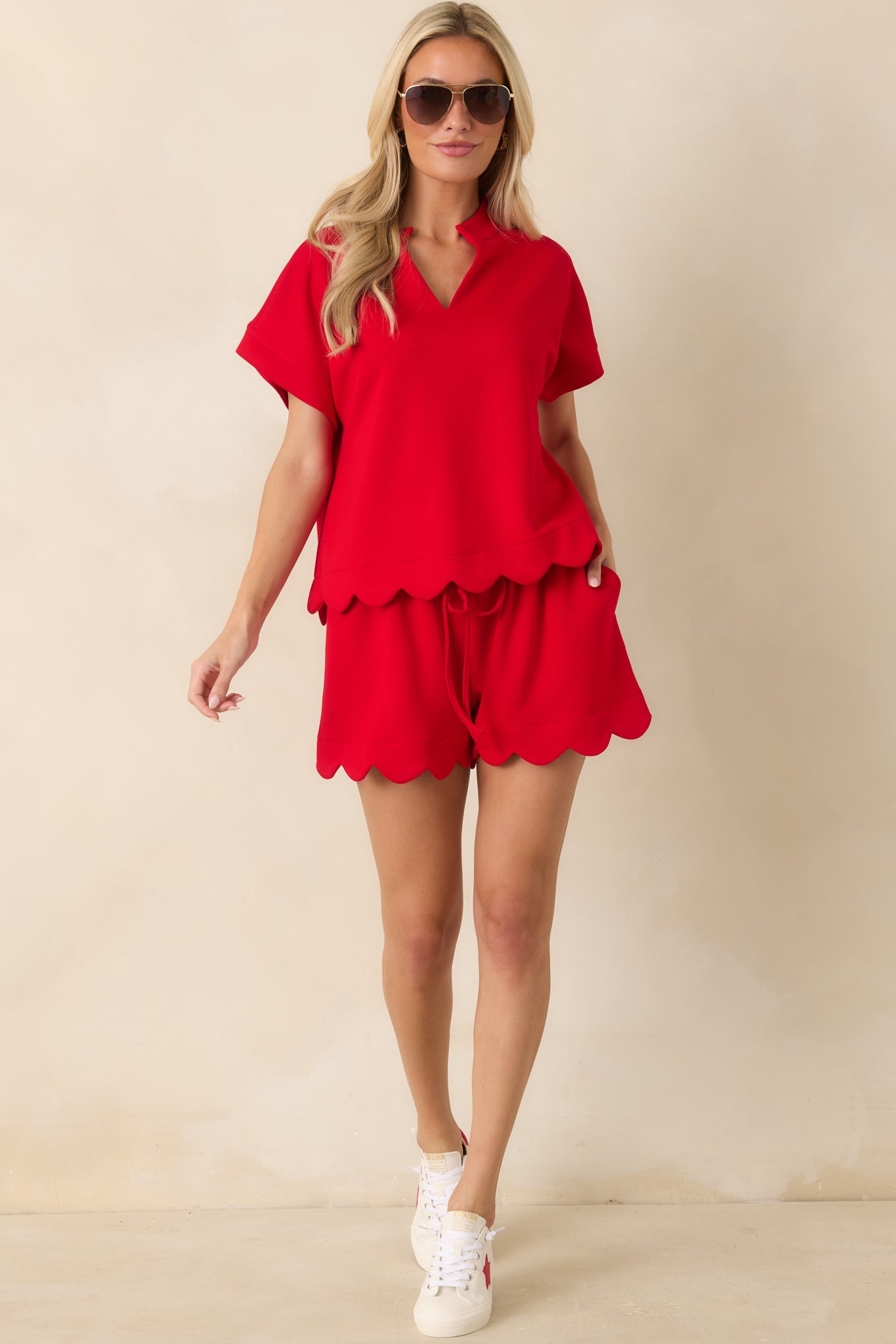 Bright red blouse with a standing collar, cuffed short sleeves, and a softly scalloped hem.
