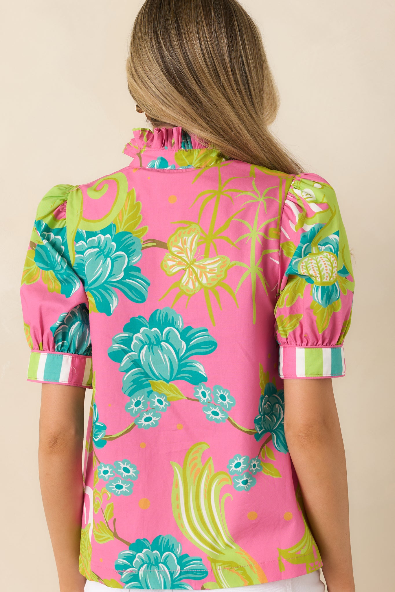 Rear view of the pink cotton blouse featuring a lightweight structured fit and softly gathered sleeve shape.