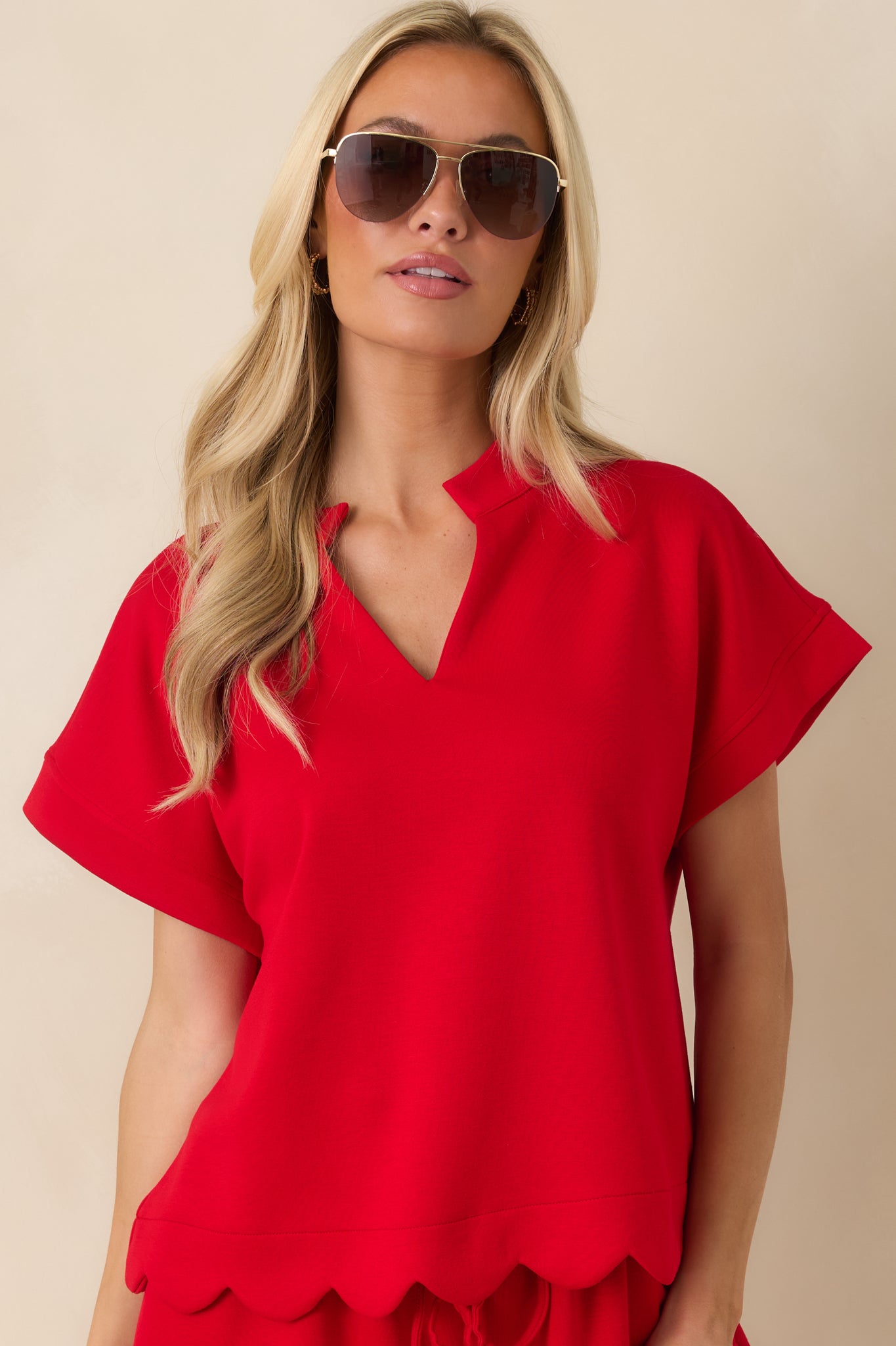 Front close-up of the red top showcasing the notched neckline and clean tailored construction.