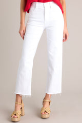 Front view of these white jeans that feature a high waisted design, classic button & zipper closure, belt loops, functional front & back pockets, a cropped length, and a raw hemline.