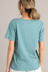 Back view of this green top that features a v-neckline, short sleeves, and a lightweight fabric.