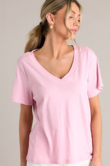 Angled close up view of this blush pink top with a graceful v-neckline, short sleeves, and crafted from a breathable lightweight fabric.
