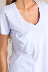 Close up view of the pocket of this vibrant iris tee with a v-neckline, practical chest pocket, ultra-soft fabric, and a gracefully scooped hemline.