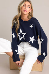 This navy sweater features a crew neckline, a slightly cropped style, a fun star print, and a relaxed fit.