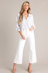 Full body view of these white jeans that feature a high waisted design, classic button & zipper closure, belt loops, functional front & back pockets, and a cropped length.