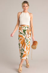 This tropical print midi skirt features a high waisted design, an elastic waist insert, self-tie wrap features, an orange & green tropical print, and a lightweight fabric.