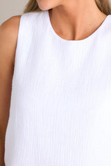 Close up view of this top that features a crew neckline, a keyhole cutout with a functional button, and a back slit.