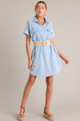 Full body view of this light chambray mini dress that features a collared neckline, functional breast & hip pockets, a relaxed fit, and cuffed short sleeves.