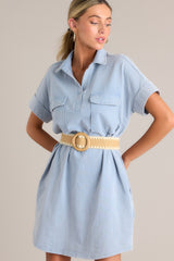 Front view of this light chambray mini dress that features a collared neckline, functional breast & hip pockets, a relaxed fit, and cuffed short sleeves.