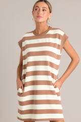 Front view of this light brown stripe mini dress that features a crew neckline, wide cap sleeves, functional hip pockets, and a relaxed fit.