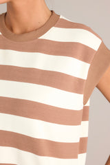 Close up view of this light brown stripe mini dress that features a crew neckline, wide cap sleeves, functional hip pockets, and a relaxed fit.