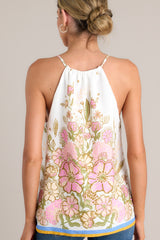 Back view of this  ivory tank top with a v-neckline featuring a self-tie feature, thin straps, a faux button front, and a unique floral pattern.