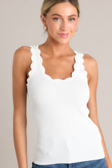 Close up front view of this ivory tank top with a scalloped scoop neckline, thick scalloped straps, ribbed texture, and a bodycon fit