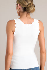Back view of this ivory tank top with a scalloped scoop neckline, thick scalloped straps, ribbed texture, and a bodycon fit