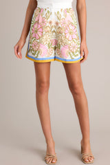 Front view of these Ivory high-waisted shorts with an elastic waist insert, hook & bar with zipper closure, functional hip pockets, and a unique floral print.