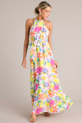 Full body angled view of this Dress with self-tie halter neckline, additional thin adjustable straps, open back, self-tie waist belt, and flowing silhouette, adorned with a multi-floral print.