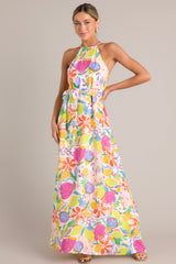 Full body view of this dress with self-tie halter neckline, additional thin adjustable straps, open back, self-tie waist belt, and flowing silhouette, adorned with a multi-floral print.