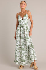 Full body view of this green toile maxi dress that features a v-neckline, thin adjustable straps, a slightly pleated bust, a smocked back insert, a thick waistband, and a flowing silhouette.