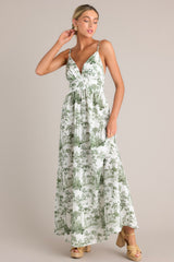 This green toile maxi dress features a v-neckline, thin adjustable straps, a slightly pleated bust, a smocked back insert, a thick waistband, and a flowing silhouette.