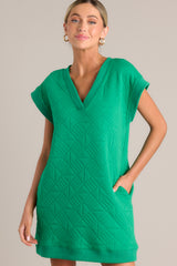 In a refreshing green hue, this mini dress showcases a flattering v-neckline, an intricate quilted design throughout, convenient hip pockets, and charming cap sleeves