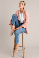 Front view of this dusty rose blazer featuring a folded neckline, shoulder padding, faux pockets, and gathering in the quarter-length sleeves.