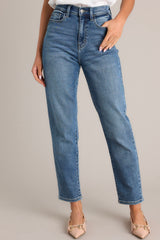 Front view of these high-waisted jeans featuring a traditional button and zipper closure, complete with functional belt loops and pockets for added convenience.