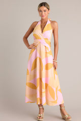 Full body view of this light pink & orange dress  features a self-tie halter neckline, open back, thick waistband, discrete back zipper, and flowing silhouette.