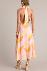 Back view of this light pink & orange  features a self-tie halter neckline, open back, thick waistband, discrete back zipper, and flowing silhouette.
