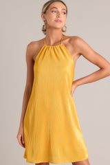Close up front view of this goldenrod mini dress that features a self-tie halter neckline, an elastic band in the back, and an all over ribbed texture.