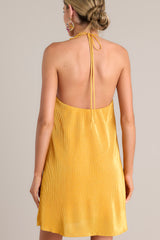 Back view of this goldenrod mini dress that features a self-tie halter neckline, an elastic band in the back, and an all over ribbed texture.