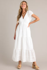 This white maxi dress features a v-neckline, a removable slip, a thin elastic waistband, functional hip pockets, all over eyelet detailing, and faux pearl trimmed sleeves.
