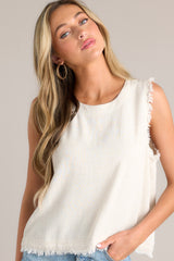 Close up front view of this sandstone tank with a crew neckline, functional buttons down the back, frayed detailing on the shoulders, and a frayed hemline.