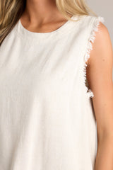 Close up view of this sandstone tank with a crew neckline, functional buttons down the back, frayed detailing on the shoulders, and a frayed hemline.