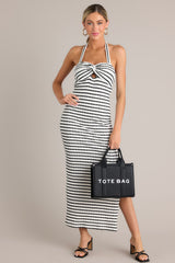 Full body view of this stripe maxi dress that features a self-tie halter neckline, twist detailing in the bust, a chest cutout, an open back, a textured material, and a side slit.