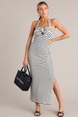 This stripe maxi dress features a self-tie halter neckline, twist detailing in the bust, a chest cutout, an open back, a textured material, and a side slit.