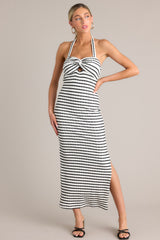 Front view of this stripe maxi dress that features a self-tie halter neckline, twist detailing in the bust, a chest cutout, an open back, a textured material, and a side slit.