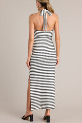 Back view of this stripe maxi dress that features a self-tie halter neckline, twist detailing in the bust, a chest cutout, an open back, a textured material, and a side slit.