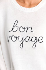 Close up view of the detailing of this white sweater that features a ribbed crew neckline, embroidered wording, a soft knitted fabric, and a ribbed hemline.