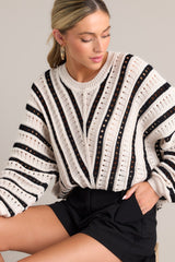 Loose fit, ecru and black knit sweater with a crew neckline and cuffed long sleeves.