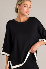 Front view of this black sweater top that features a crew neckline, a relaxed fit, split quarter sleeves, and contrasting split hemlines.